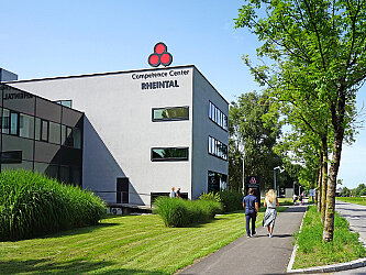 Competence Center RHEINTAL im Millennium Park in Lustenau mit Spaziergängern.